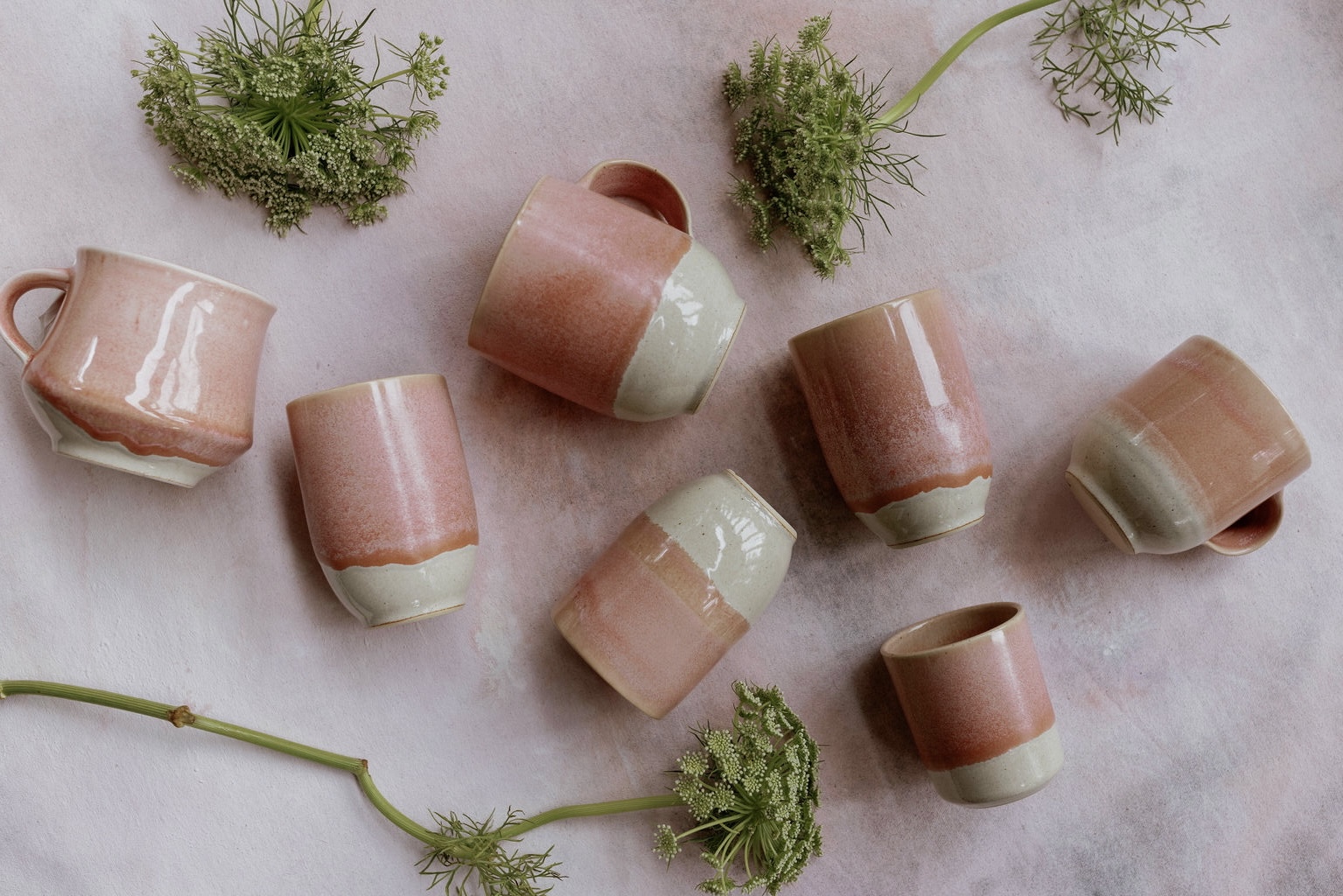 Pink handmade ceramic cups styled with garden flowers