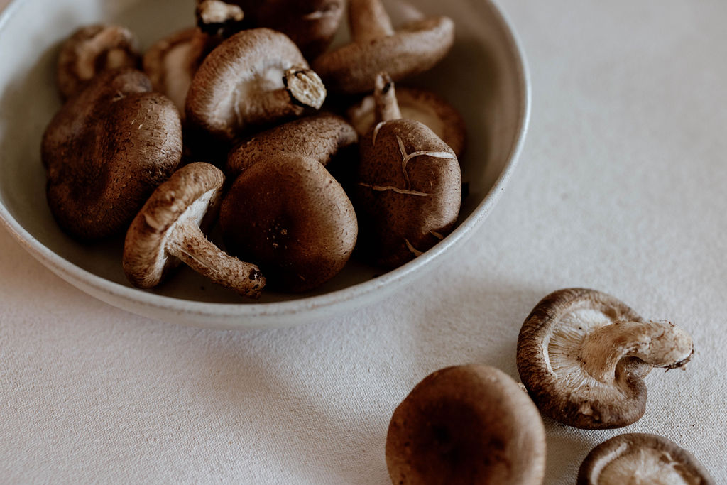 Shiitake mushrooms gathered in a handmade ceramic bowl